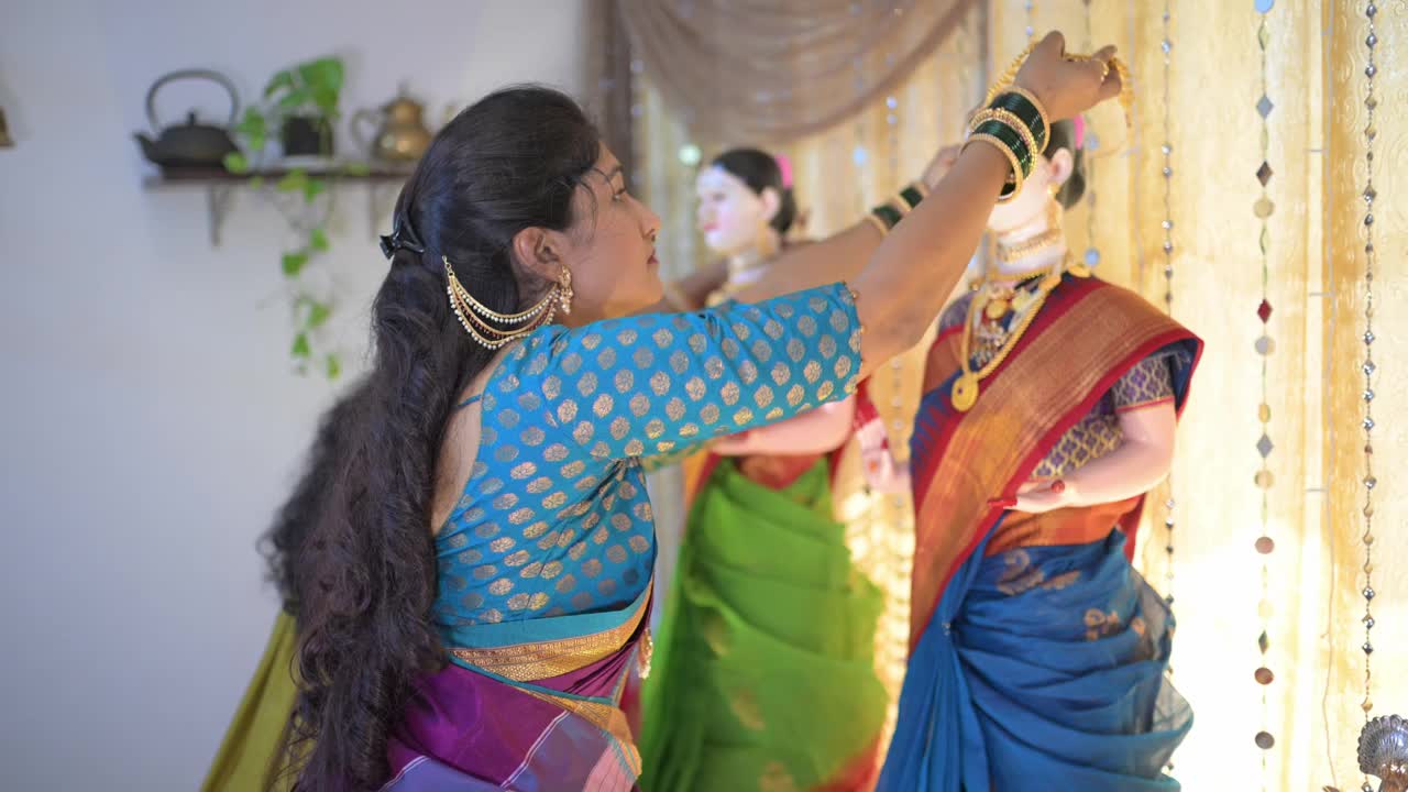 在Ganapati节期间，家中的中年妇女优雅地用装饰品装饰Gauri神像视频素材