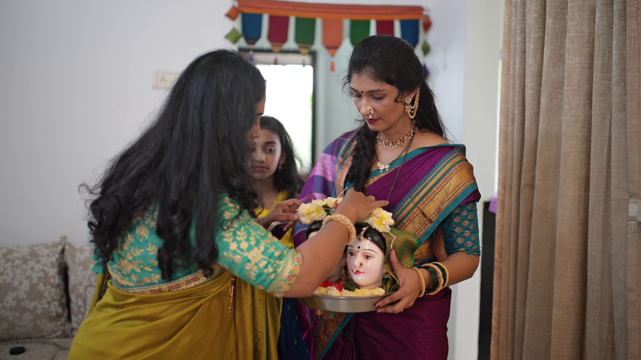 在Ganpati节期间，印度妇女优雅地带着Gauri神像进入家中视频素材