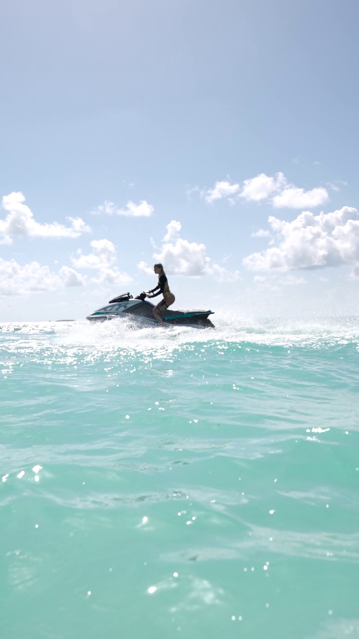垂直视频的年轻女子驾驶喷气船在夏天的一天在海上。视频素材