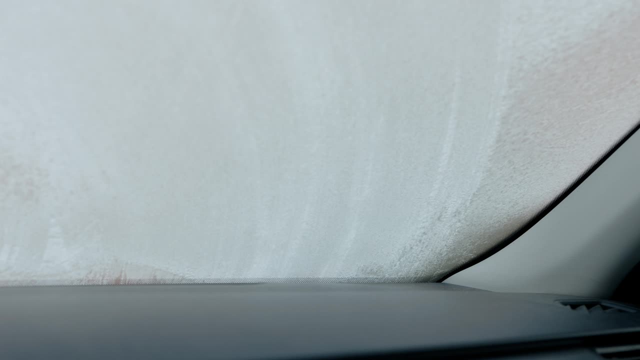 在一个寒冷的冬天早晨，一名男子在抓挠他的汽车前窗视频下载