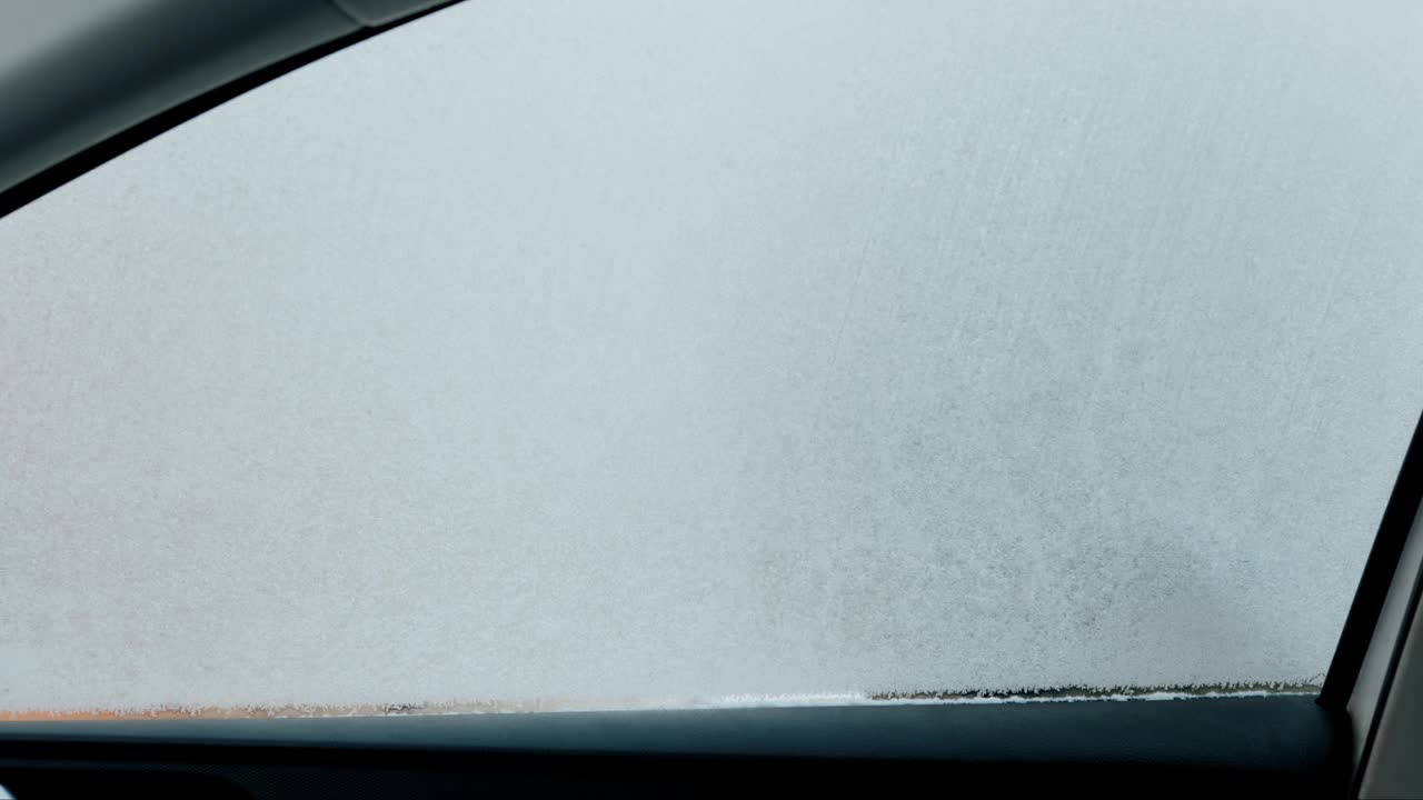 在一个寒冷的冬天早晨，一名男子在车内抓挠自己汽车的侧窗视频下载
