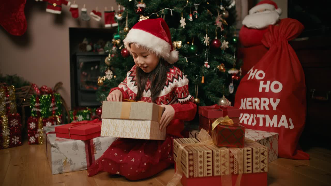 快乐的小女孩正在打开她的圣诞礼盒视频购买