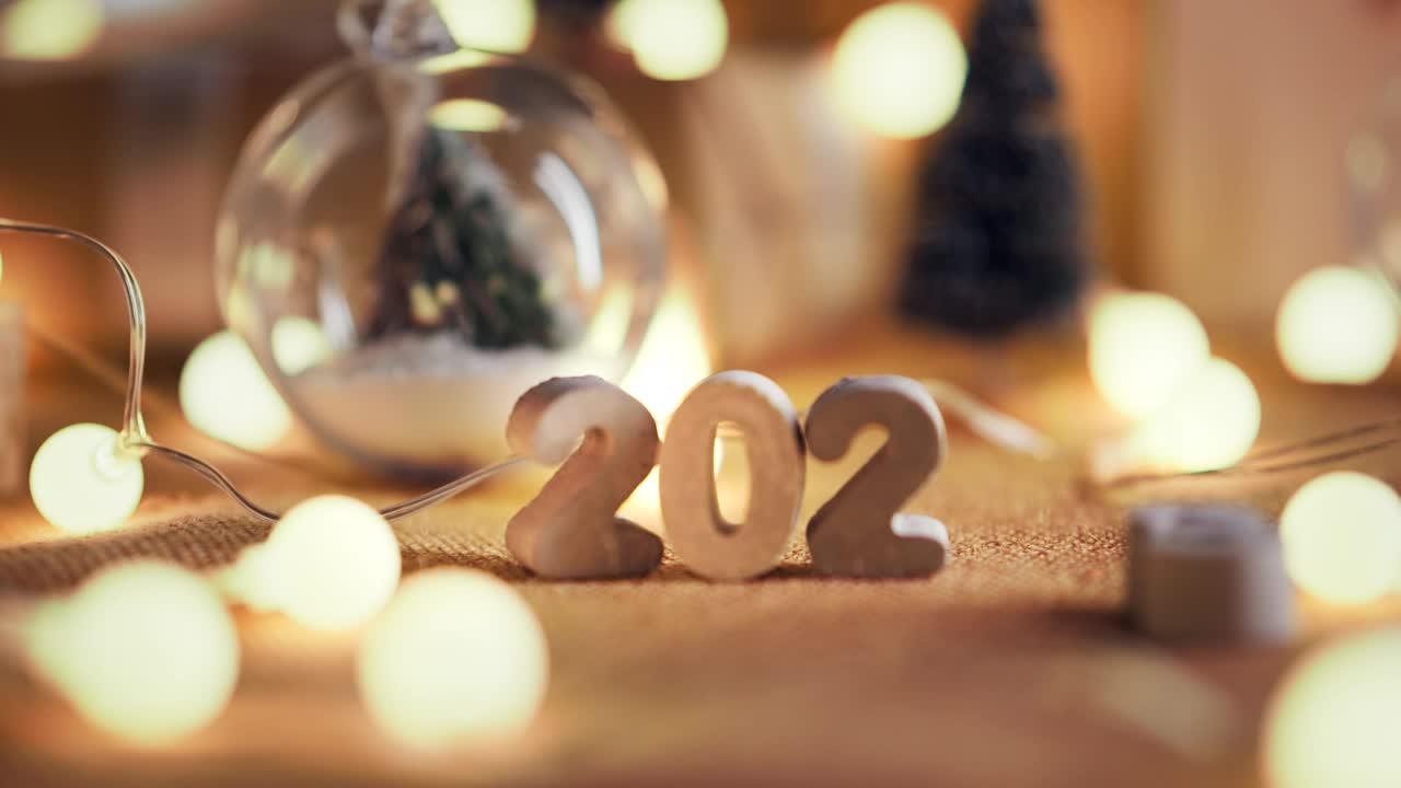 女人的手把2024数字装饰的桌子上，圣诞快乐，新年快乐!视频购买