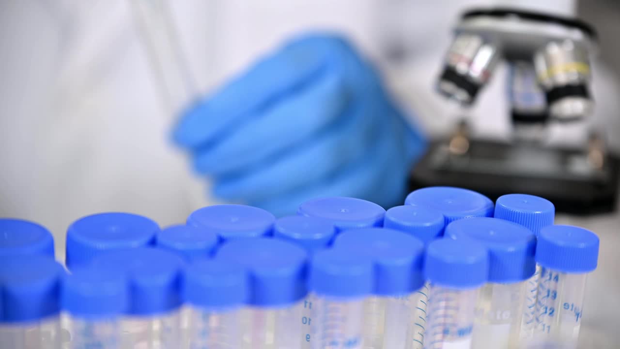 科学家戴着蓝色手套，使用实验室工具的特写视频下载