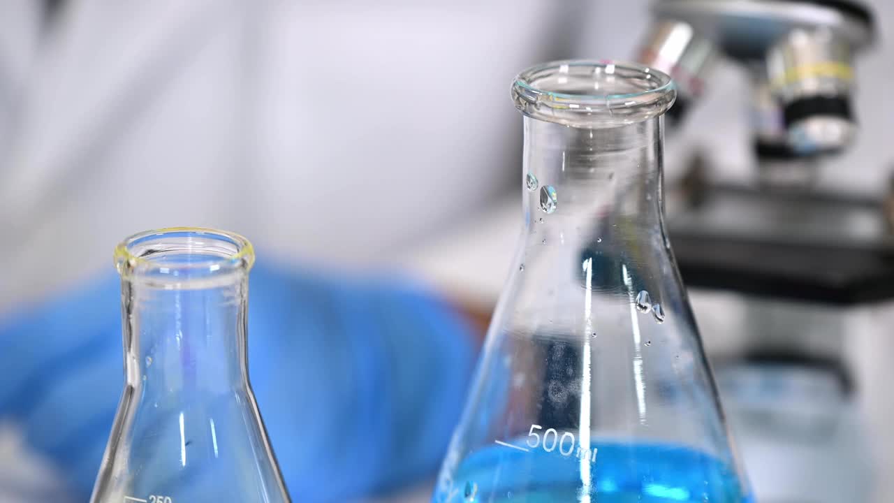 科学家戴着蓝色手套，使用实验室工具的特写视频素材