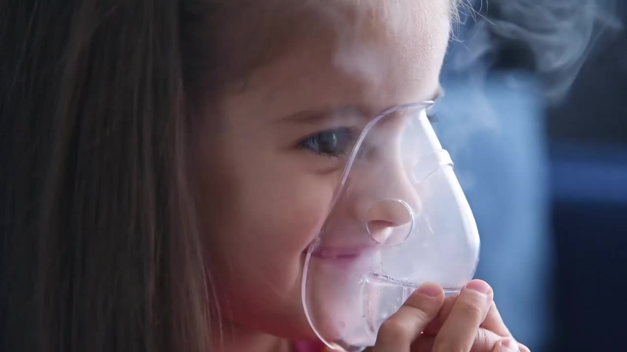 快乐的小女孩用喷雾器吸气。视频下载