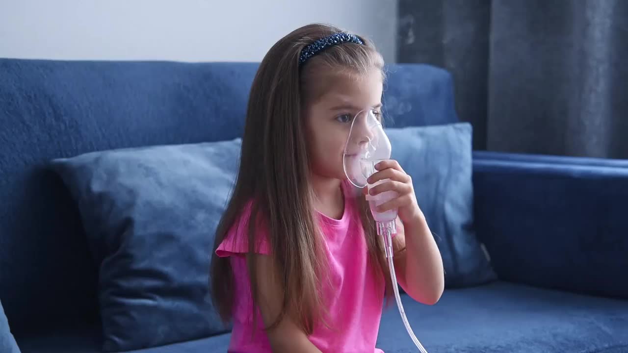 小女孩用喷雾器吸气。视频下载