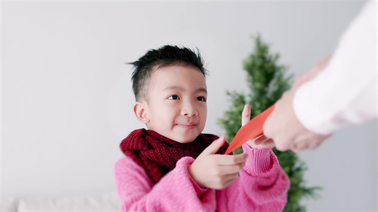 快乐的亚洲小男孩收到红包，庆祝中国新年视频下载