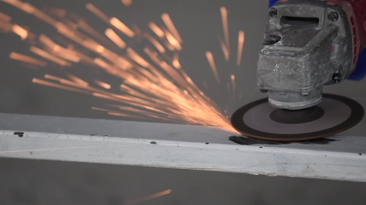 慢动作视频，一个焊工戴着安全手套在磨钢门窗。安全理念与机械工业视频下载