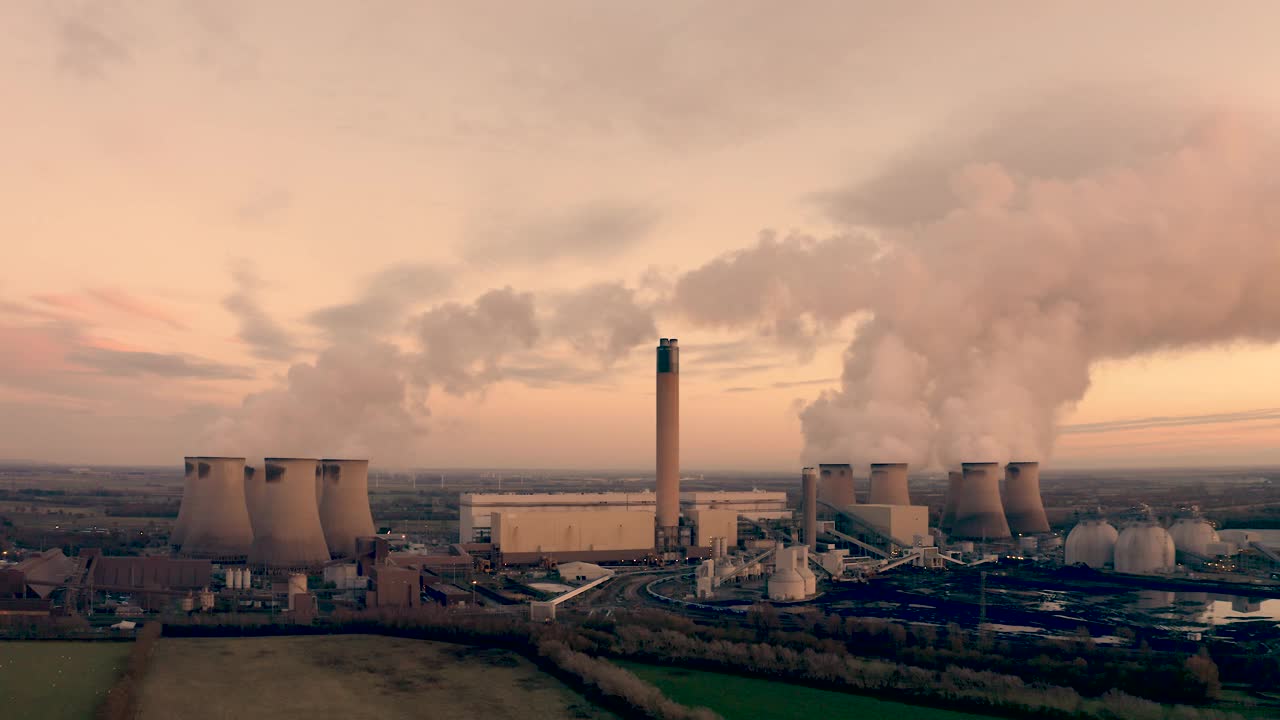 日落时二氧化碳排放的燃煤发电站的4K鸟瞰图视频素材
