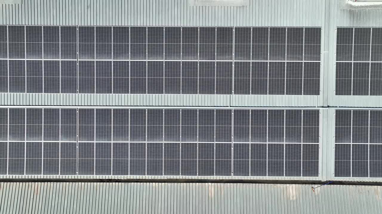 一名技术工程师在屋顶上检查和修理太阳能电池板的鸟瞰图视频下载