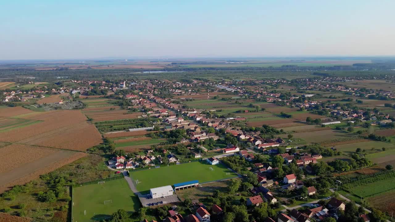 鸟瞰塞尔维亚Belegis小村庄周围的绿色和金色的耕地视频下载