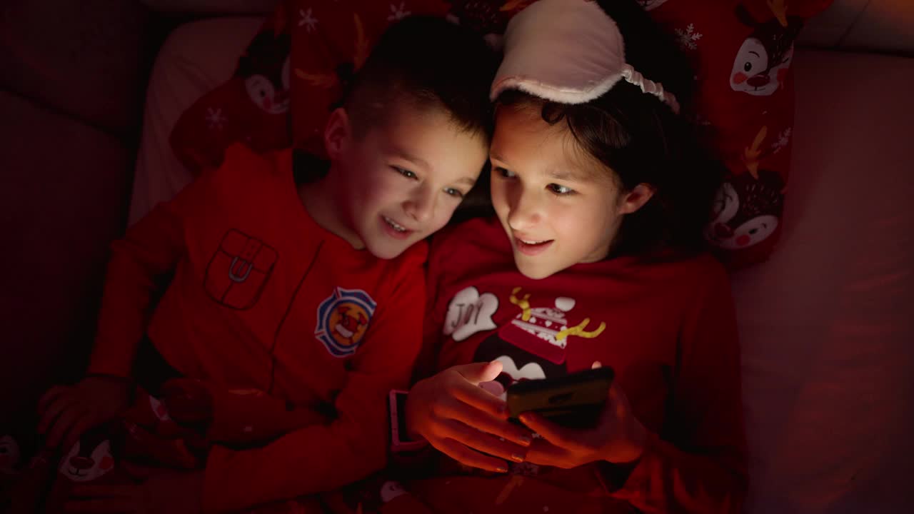 兄妹俩在睡前玩智能手机视频下载