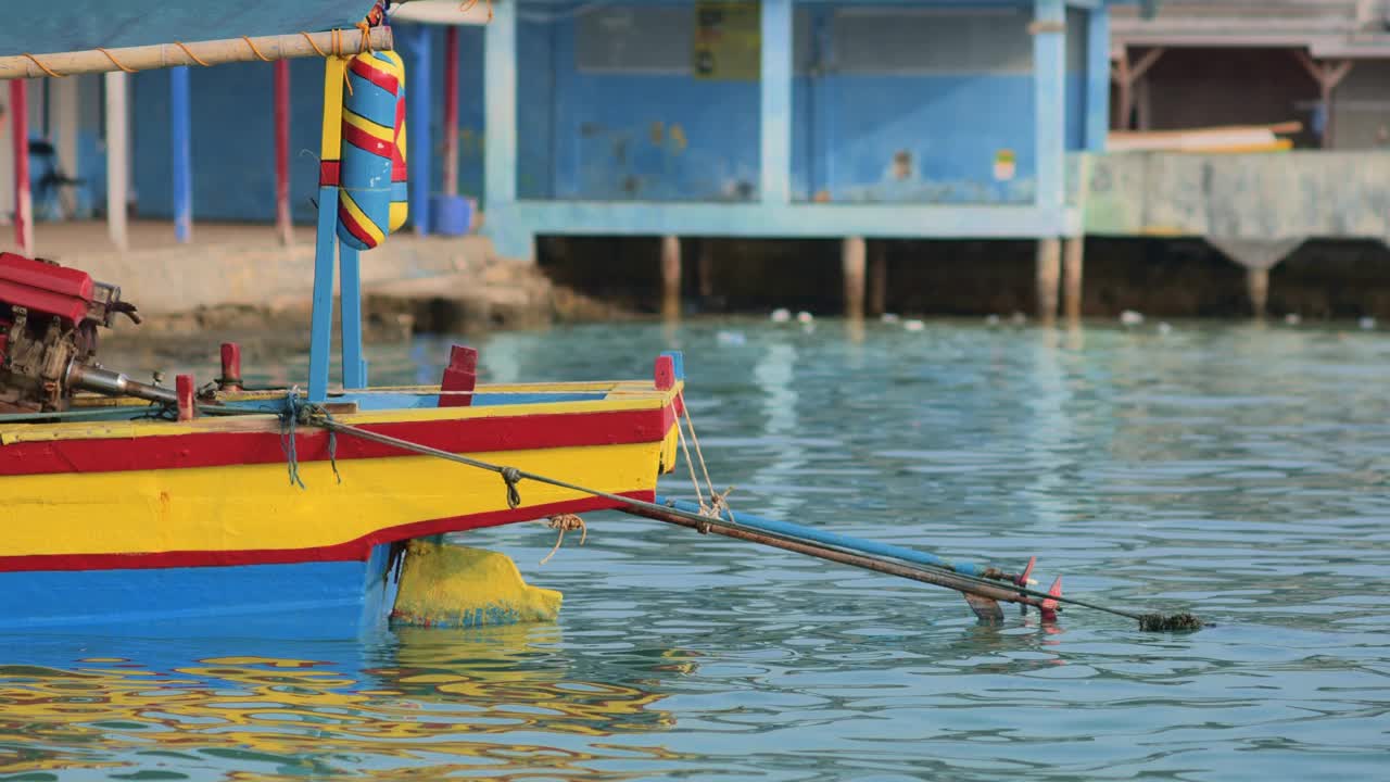 清晨，五颜六色的印尼渔船停靠在楠榜岛的海岸上，随着海浪摇摆。视频素材