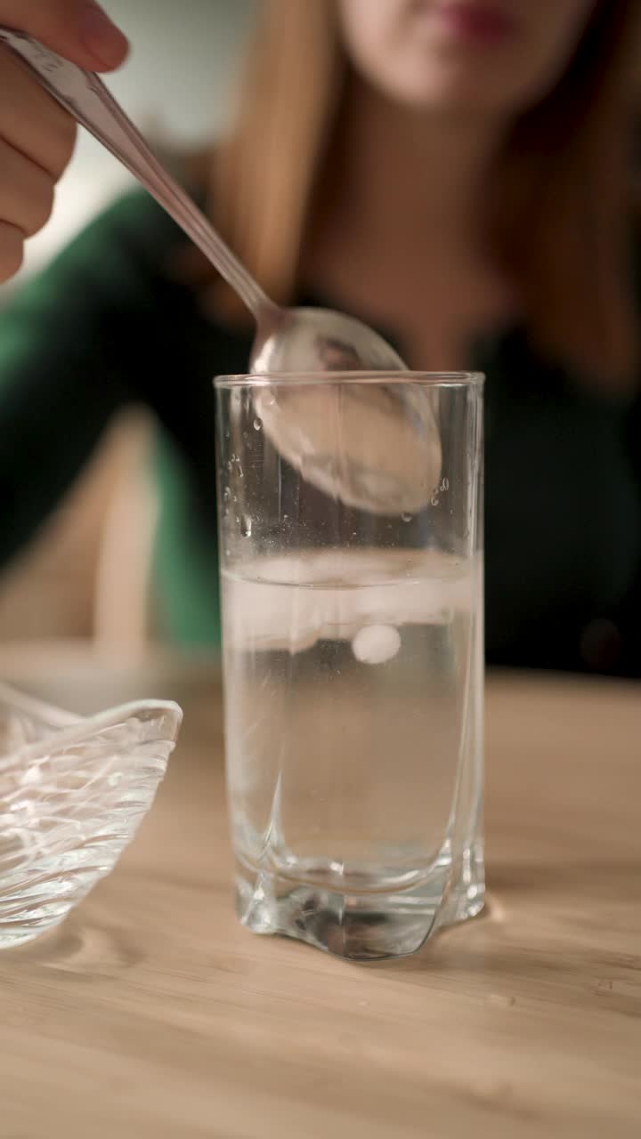 一个女人因为牙痛，从饮水杯里舀出冰块视频下载