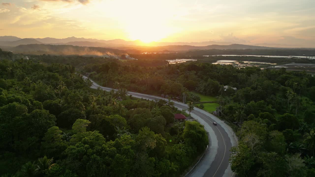 热带乡村，树木环绕着夕阳下的道路视频下载