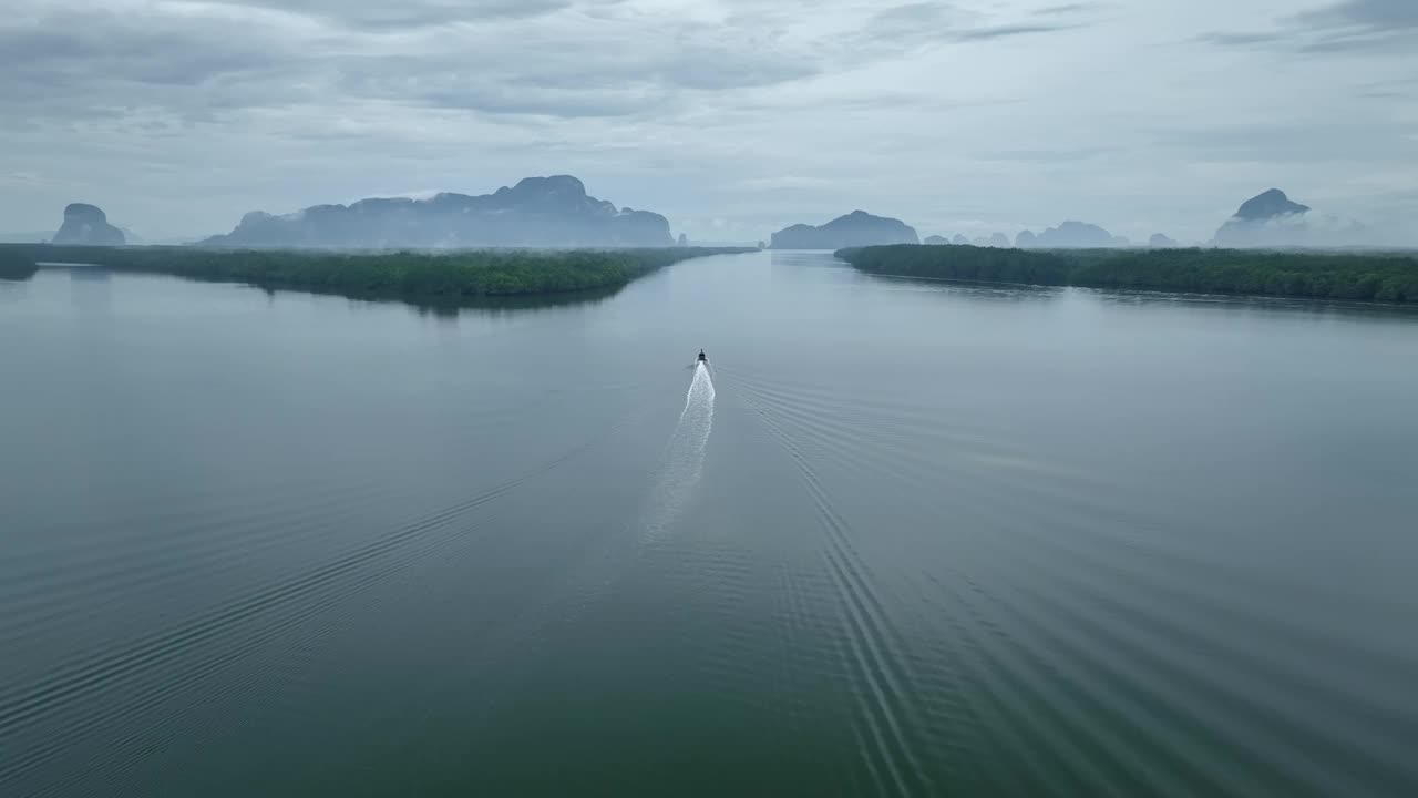 无人机跟踪一艘船在河上的红树林，泰国视频下载