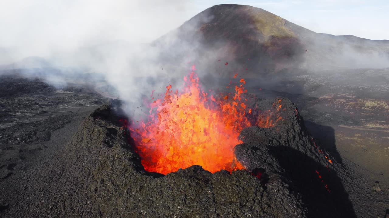火山喷发，炽热的熔岩从地面喷出，无人机飞过活跃的火山口。自然灾害和气候变化。构造活动。火山喷发2023年，冰岛。以5k分辨率拍摄视频下载