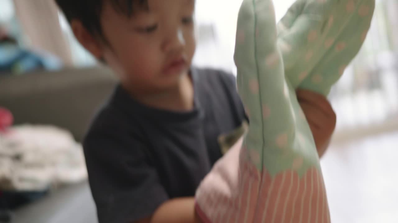 快乐的亚洲男孩和爸爸玩隔热手套玩得很开心。视频下载