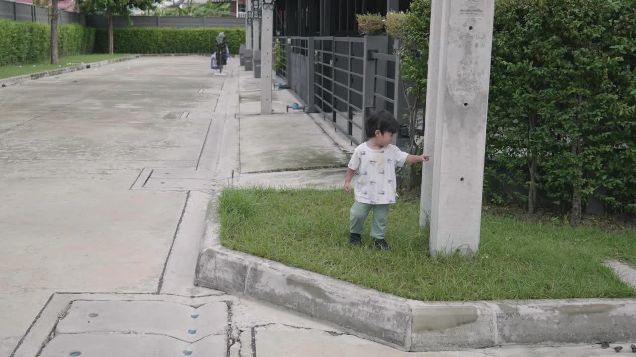 快乐的亚洲男孩在家里走来走去。探索周围的事物。视频下载