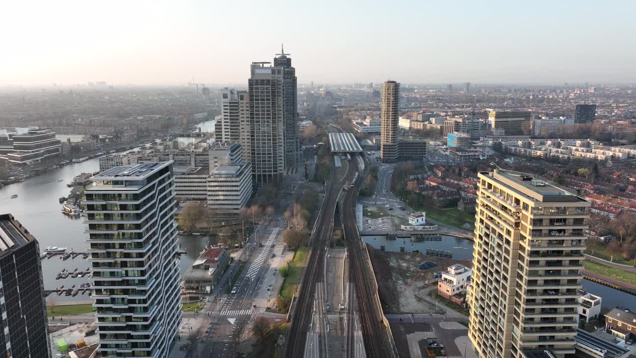 阿姆斯特丹阿姆斯特尔市城市无人机航拍交通和城市住宅建设塔。基础设施、火车站、商业大楼和天际线。水运河。视频下载