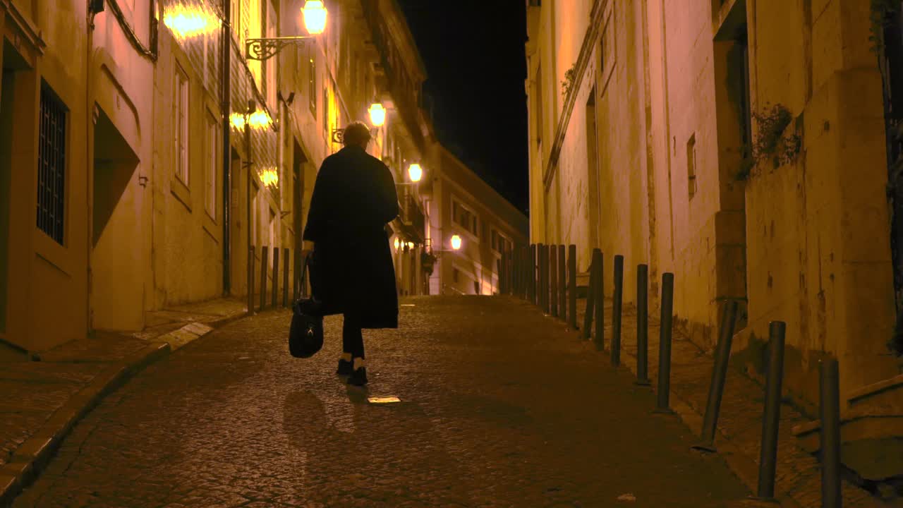 一个背着包的男人走在夜晚的欧洲城市视频下载