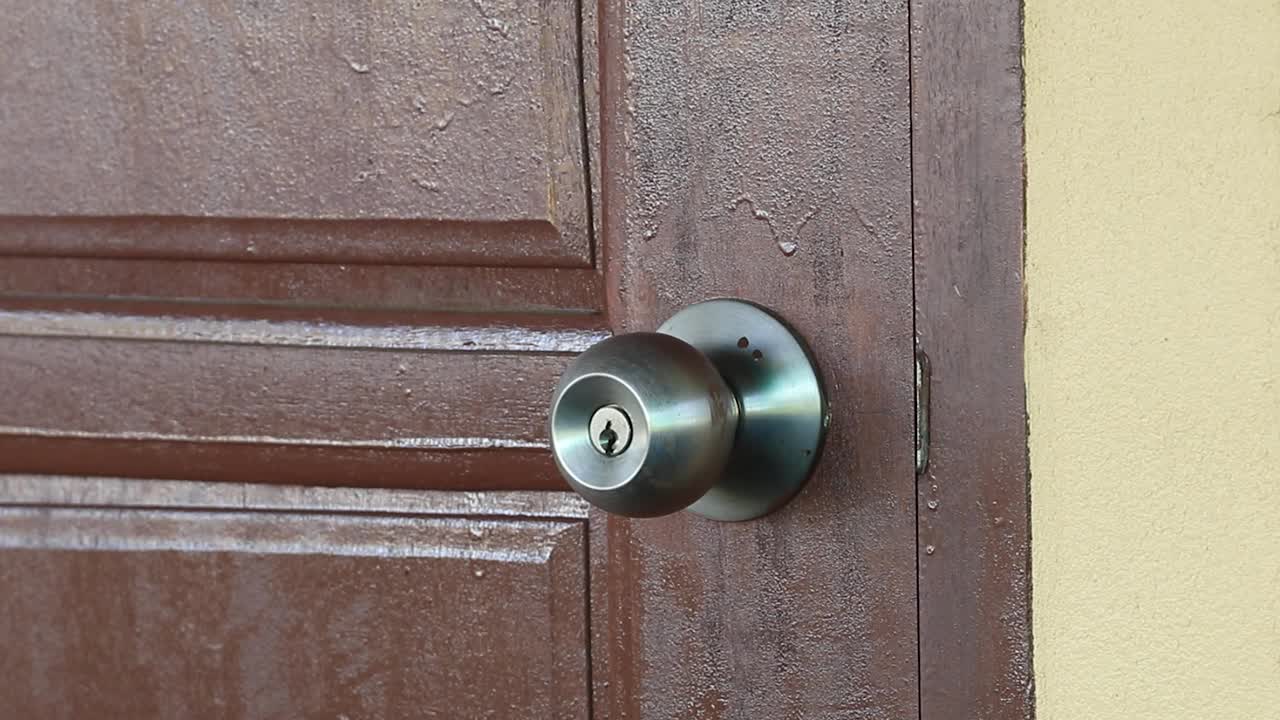 用于打开和关闭您的家和财产安全的木门，门把手和钥匙。防贼防贼。一扇坚固的木门，保护隐私和财产。视频素材
