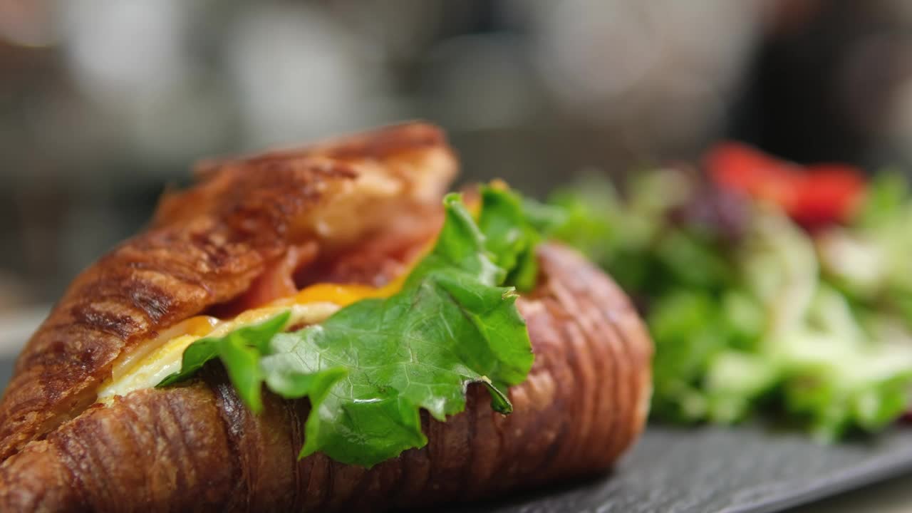 美味的牛角包，火腿和奶酪放在白色盘子旁边的沙拉视频下载