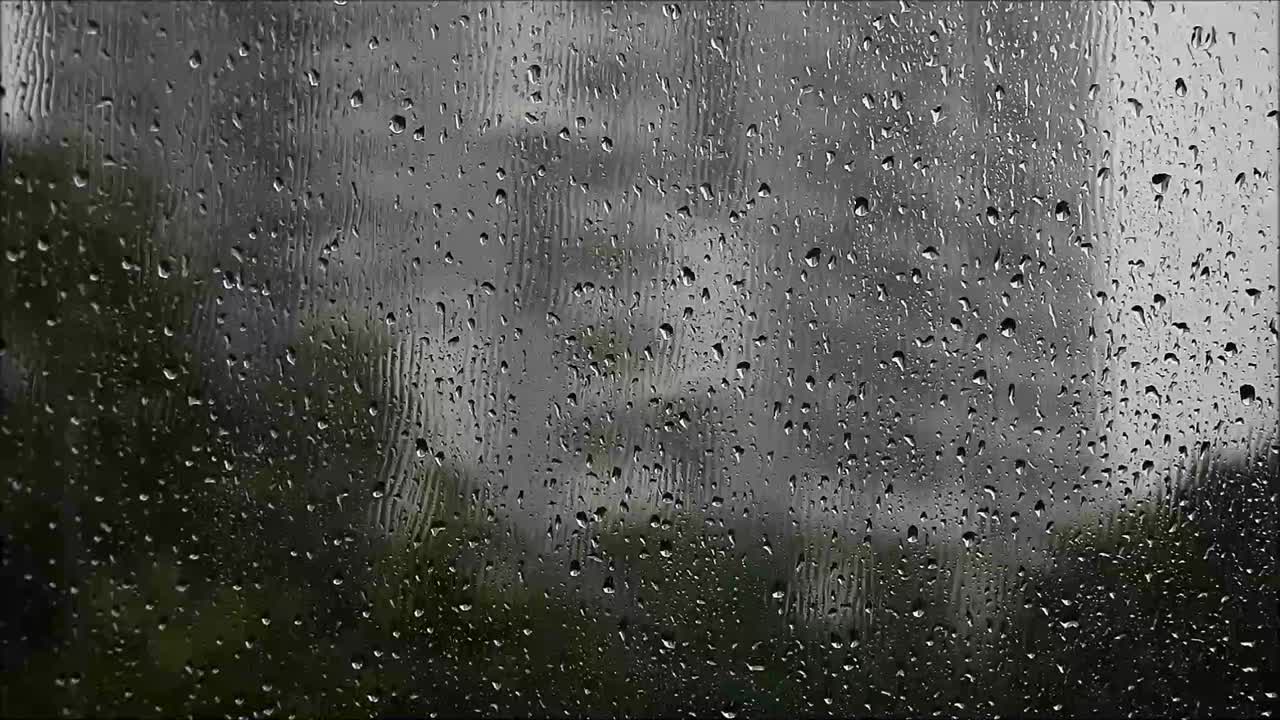 小雨时雨滴落在窗户玻璃上的镜头视频下载