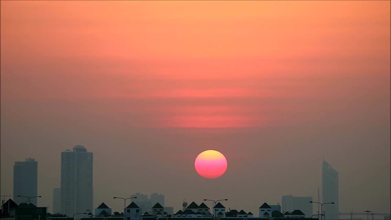 令人惊叹的珊瑚粉色太阳落在城市天际线的延时镜头视频下载