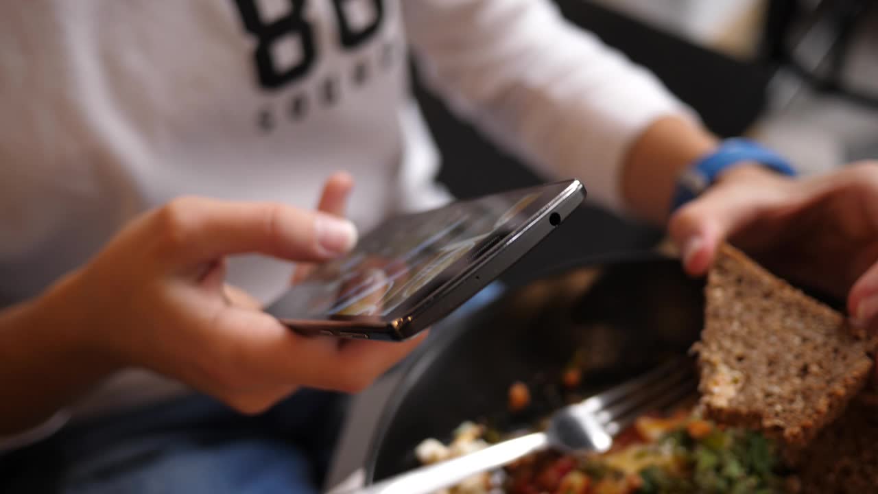 女孩在咖啡厅小吃店吃饭，用手机拍下午餐照片发到社交媒体上视频下载