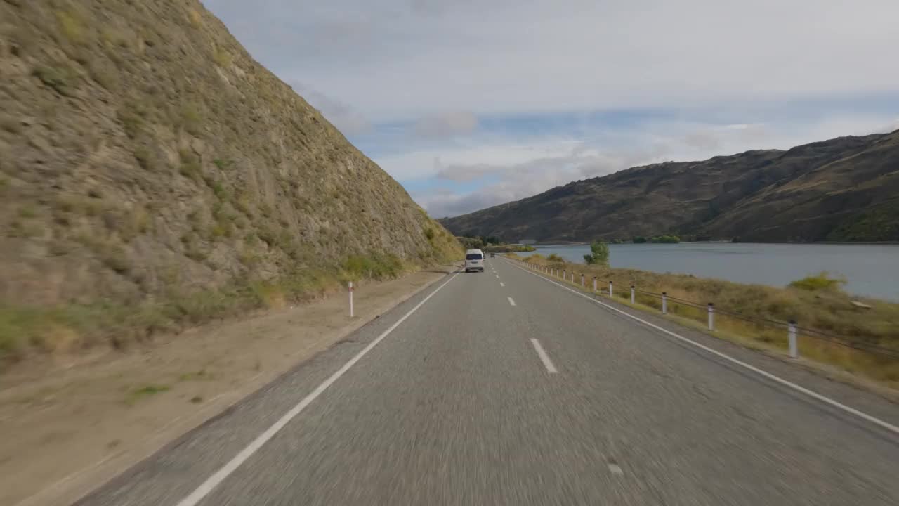 在新西兰奥塔哥的克莱德，汽车行驶在经过克莱德大坝的路上。视频下载