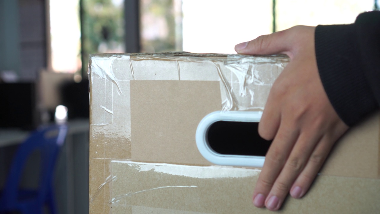 手提包裹递送员拿着寄件箱到业主/派递处。送货邮递员将大纸板送到货主跟前，向客户提供送货订单电子商务服务视频素材