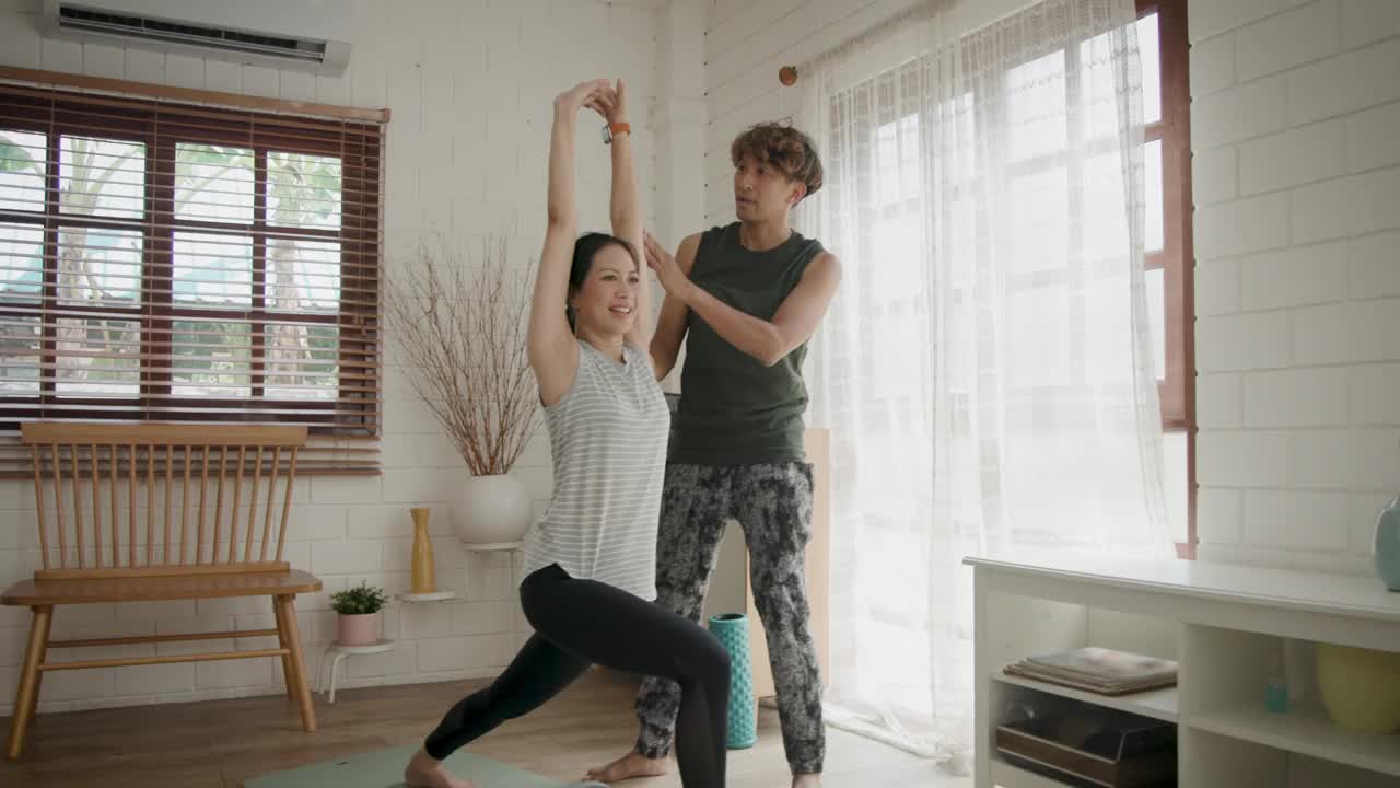 亚洲成熟夫妇在家里一起做瑜伽或力量训练视频素材