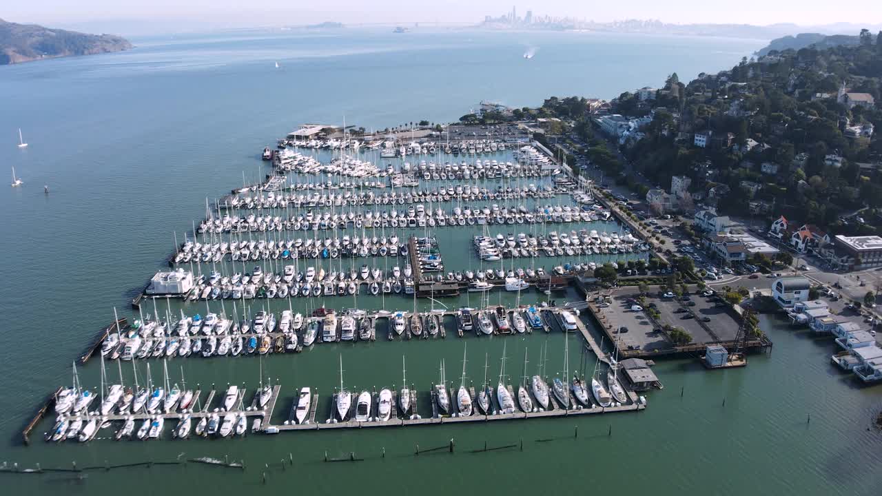 无人机降落在索萨利托的码头上，展示了一排排停泊的船只和旧金山附近迷人的沿海小镇。视频素材