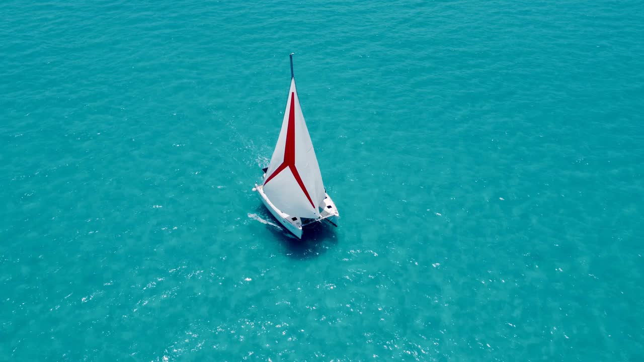 在巴哈马碧绿的海水中，一艘帆船双体船的鸟瞰图视频素材
