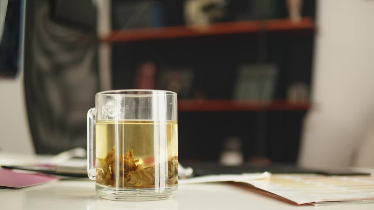 办公桌上的一杯绿茶。蒸汽上升。视频下载