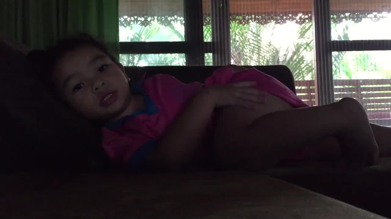 一个亚洲小女孩在客厅的沙发上玩耍视频下载