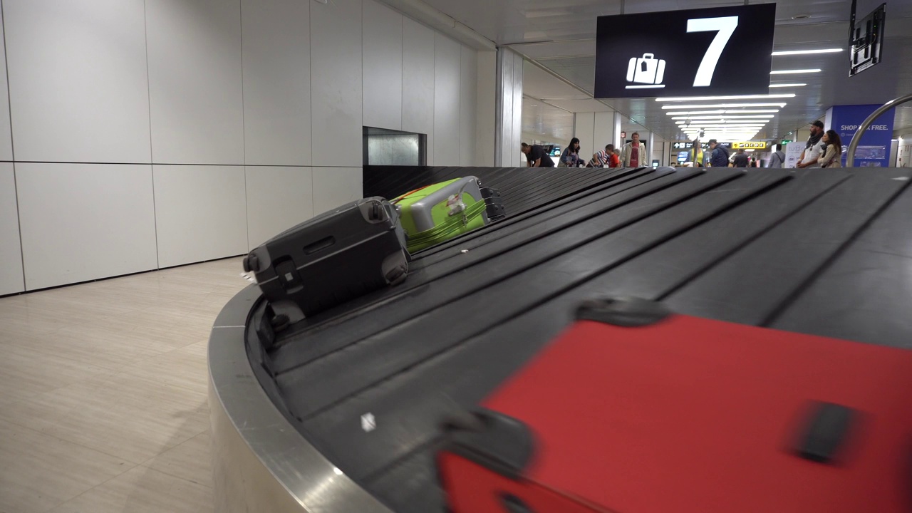 万向节。旅客在行李领取处搬运行李。4 k。视频下载