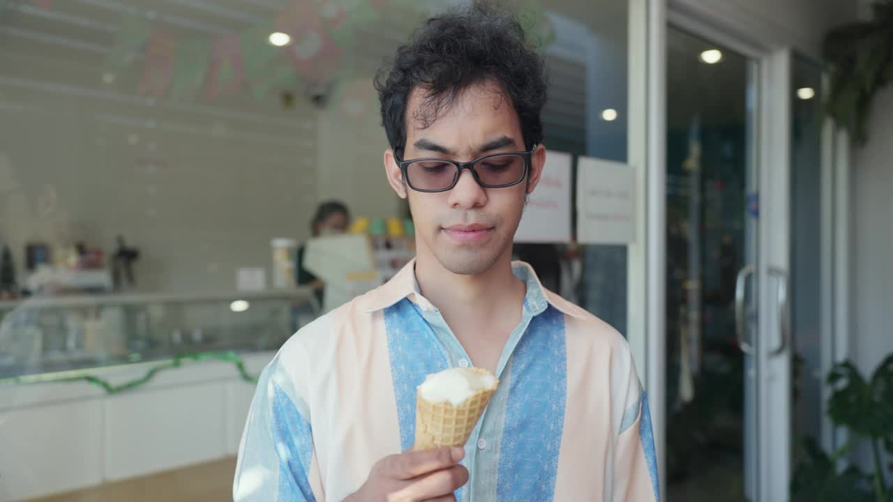 亚洲中年男子用勺子从威化筒里舀冰淇淋，以保护牙齿敏感。亚洲男性在吃冷甜点后牙痛，虽然用勺子吃冰淇淋。视频下载