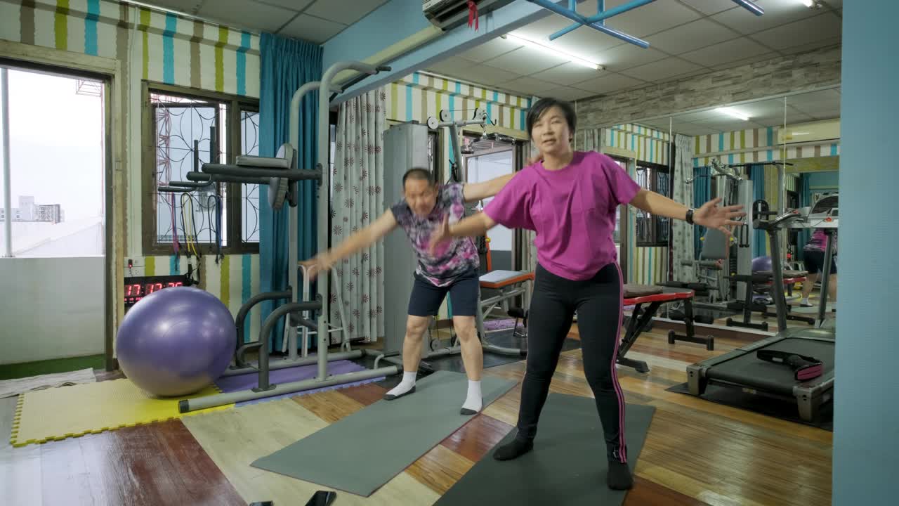 亚洲成熟夫妇在家里的健身房或健身俱乐部一起做力量训练和身体锻炼视频下载