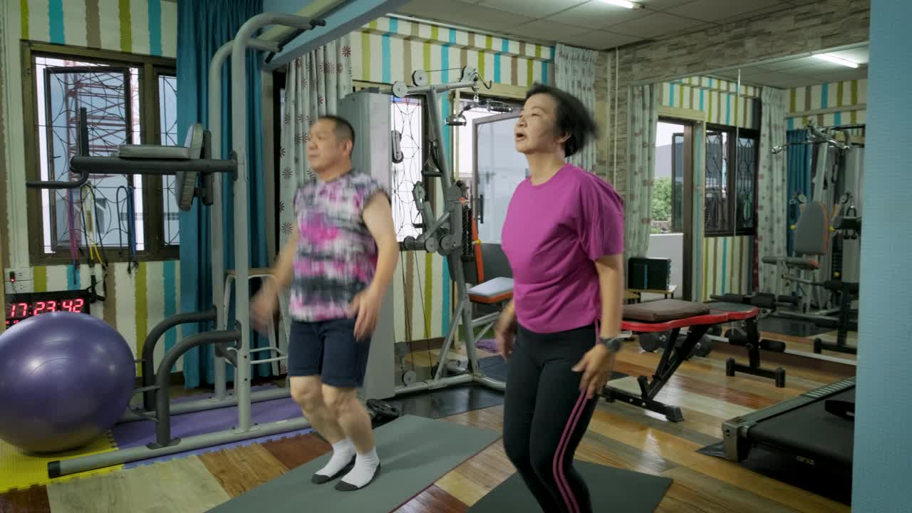 亚洲成熟夫妇在家里的健身房或健身俱乐部一起做力量训练和身体锻炼视频下载