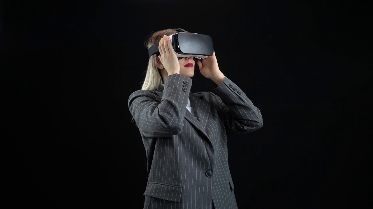 在办公室使用虚拟现实眼镜的女企业家。一位戴着虚拟眼镜的女性，黑色背景。视频下载