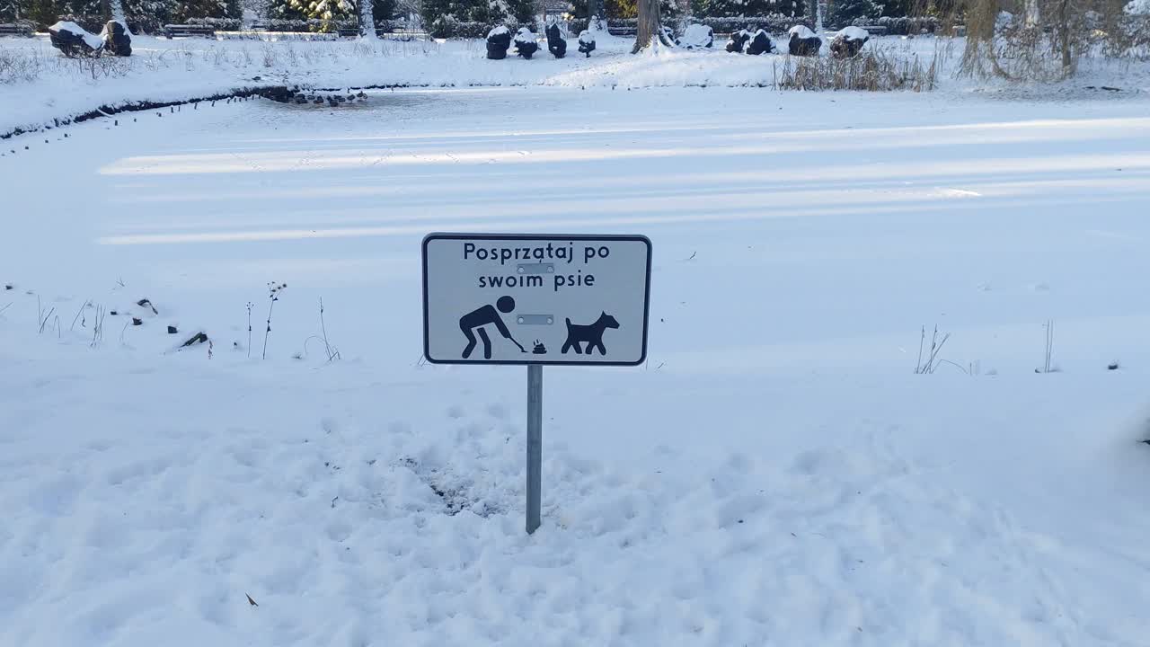 冬季城市公园的标牌上写着波兰语:清理狗狗的粪便视频下载