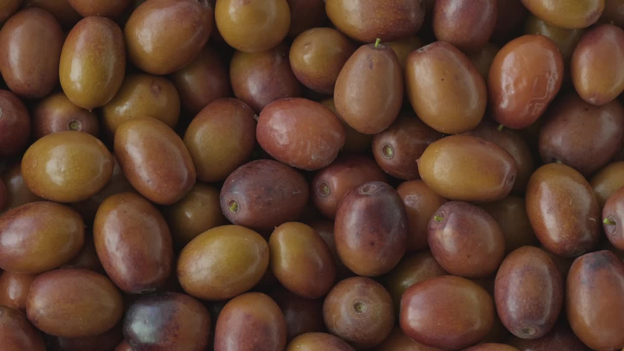 枣子或酸枣背景水果旋转。收获成熟有用的浆果。酸枣果实(尤纳比常见，中国玉巴-枣树的外来果实)视频下载