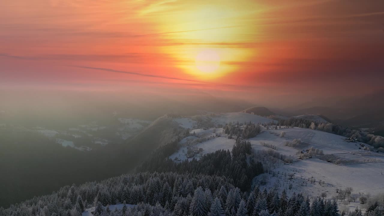 无人机拍摄的冬季日落时雾气蒙蒙的森林视频下载