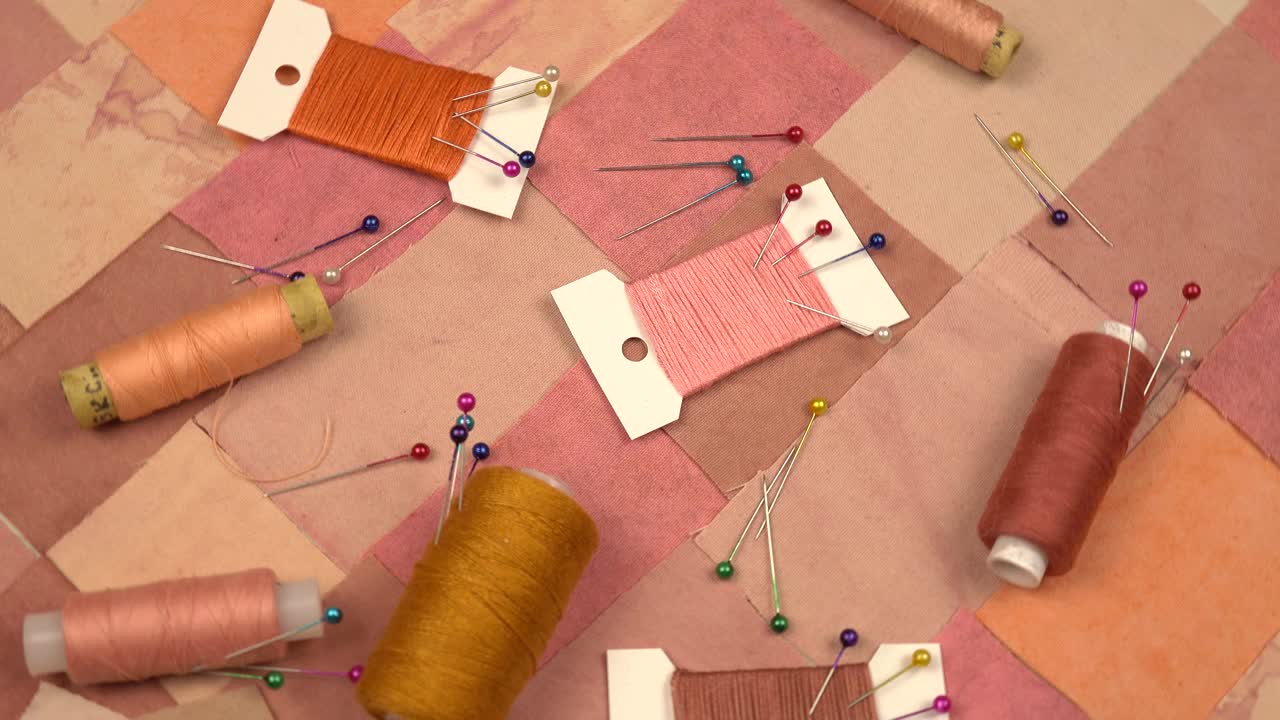 用于拼接缝纫的配件放在粉红色和棕色调的拼接纺织品上视频下载