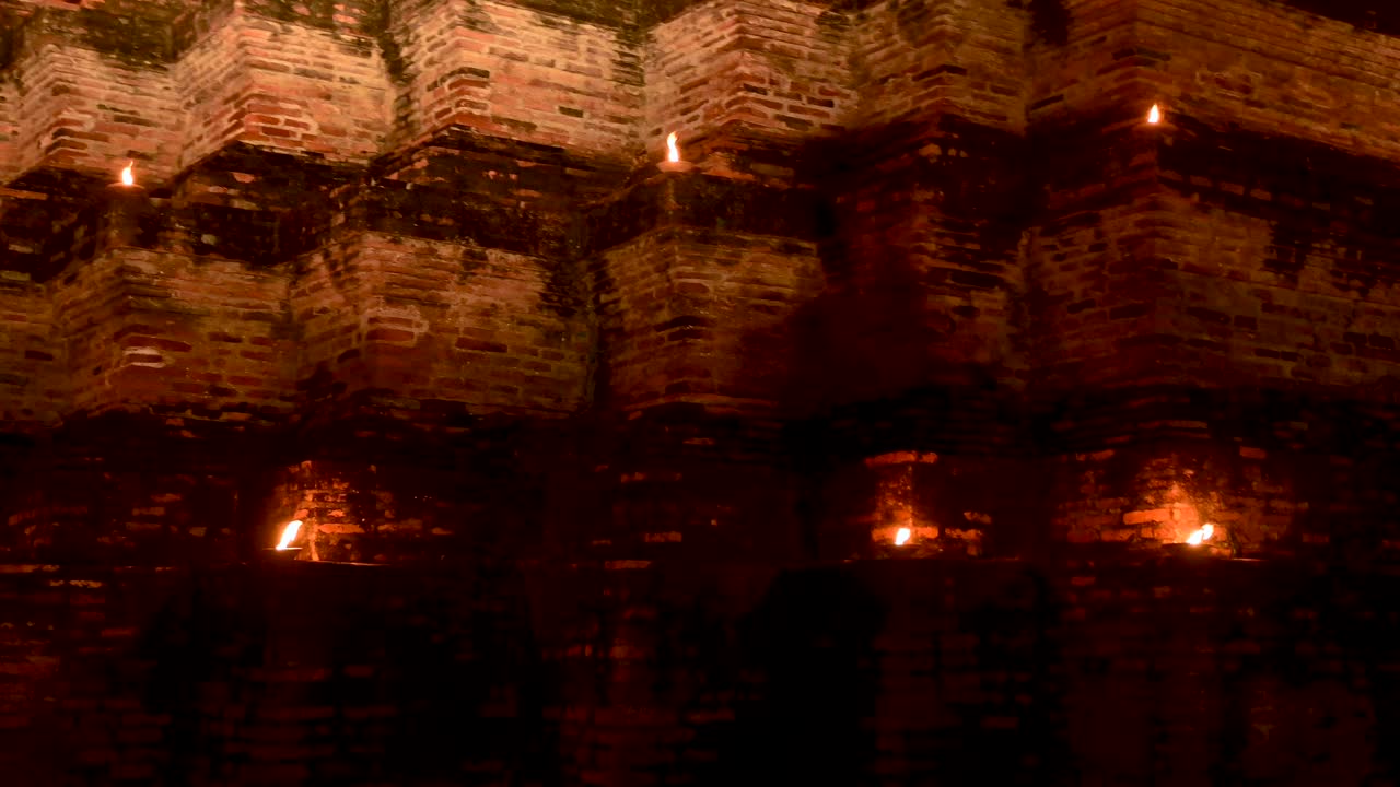 泰国素可泰，新年前夜，烛光照亮了摩哈塔寺的宝塔视频下载