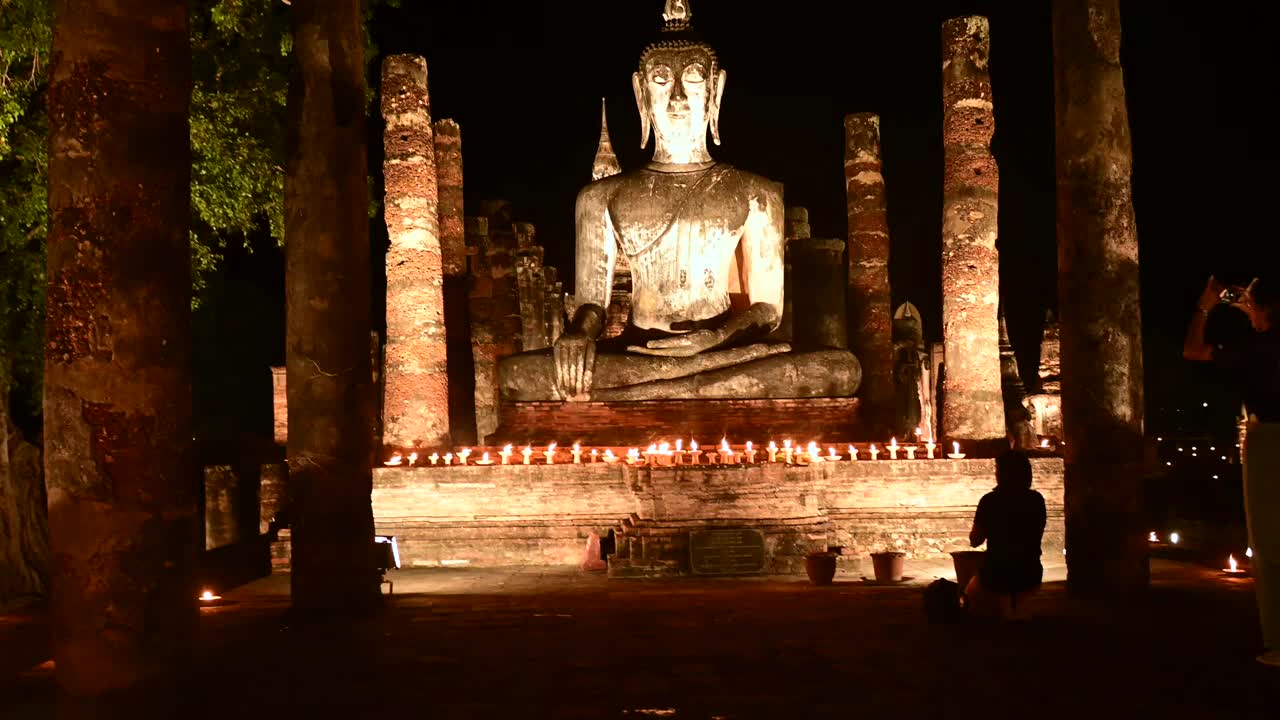 泰国素可泰，摩诃寺废墟上的大佛在夜晚被照亮视频下载