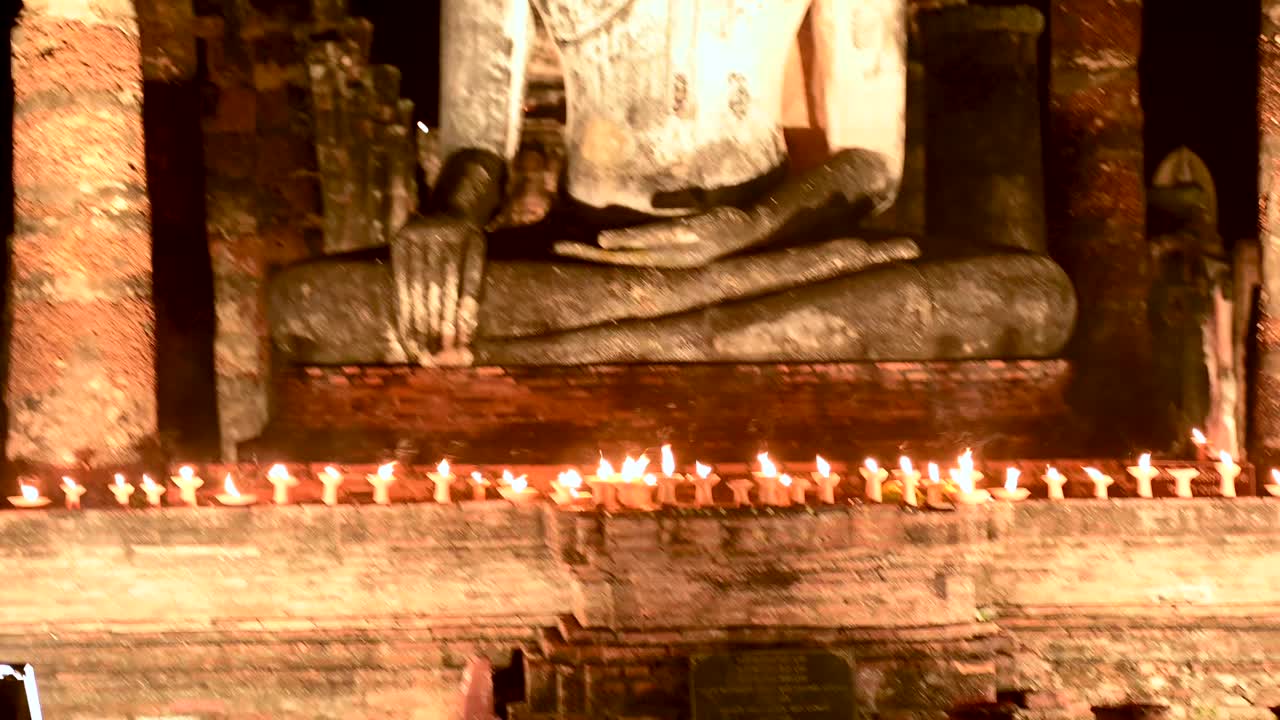 泰国素可泰，摩诃寺废墟上的大佛在夜晚被照亮视频下载